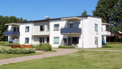 Lägenhetshus i två våningar med balkonger och uteplatser i markplan