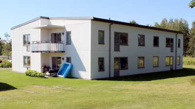 Lägenhetshus i två våningar med balkonger och uteplatser i markplan