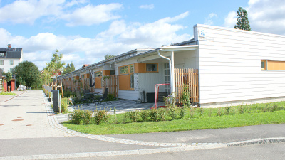 Entrésidan av Hamre Gård, envånings radhus med plattor vid entréerna.