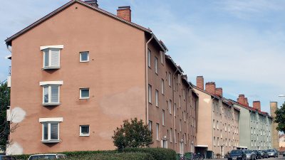 Lägenhetshus två sektioner som har olika färg på fasaden som är i puts. Husen har tre våningar.