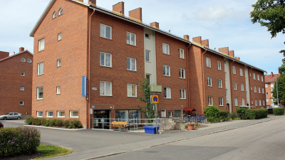 Flerbostadshus i tre våningar i rött tegel. Bovärdskontoret ligger i markplan.