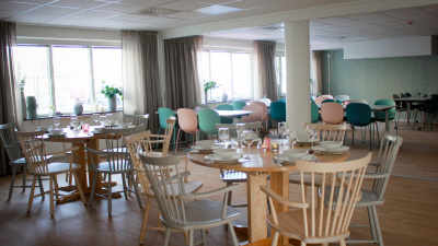 Interiörbild gemensamma köket Hedhamregatan 1. Bord och stolar i glada färger.