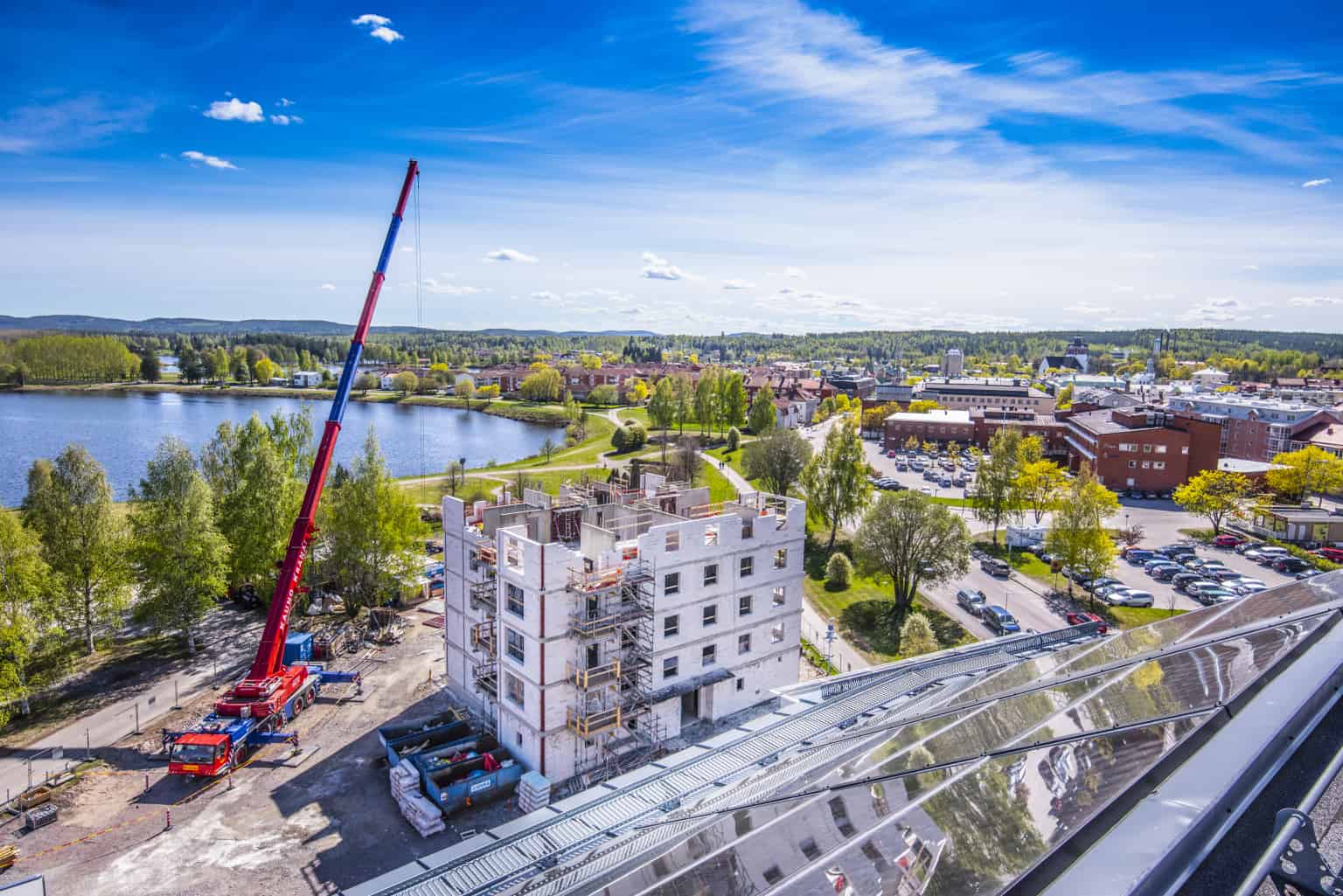 Flerbostadshus under uppbyggnad.. Fotot är taget uppifrån och du ser en byggkran och Bollnäs stad i bakgrunden.