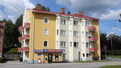 Flerbostadshus Kransgatan 3. Hus i tre våningar med putsad fasad I markplan ligger en pizzeria.