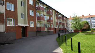 Flerbostadshus i tre våningar och rött tegel, Ljusa partier vid entrérna.