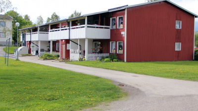 Flerbostadshus, gräsmatta och grusväg