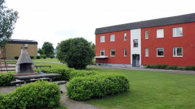 Bild på grillplats på innergård vid Skolmästaren i Arbrå och flerbostadshus i bakgrunden.