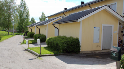 En innegård vid ett bostadsområde med hus i träfasad.