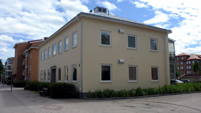 Flerbostadshus i ljusgul stenputs. Huset har två våningar.