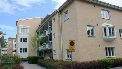 Flerbostadshus i ljust tegel. Huset har tre våningar och loftgång.