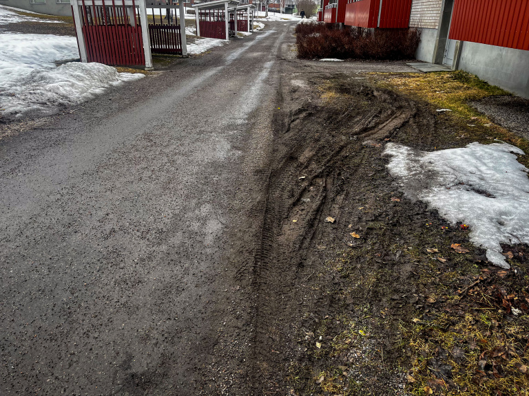 Sönderkörd gräsmatta utanför hyreshus